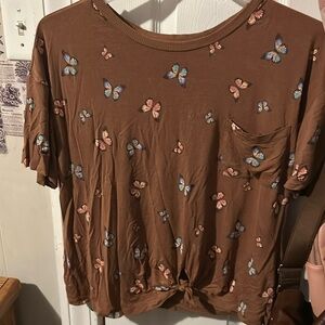 This is a brown crop top with blue and pink butterfly’s on it.